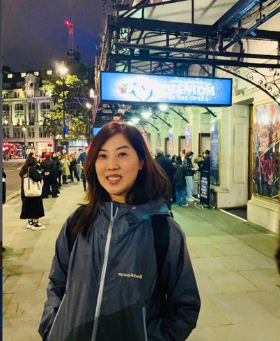 Portrait of Dorothy smiling in front of a theatre entrance in the evening