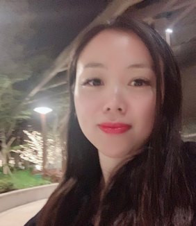 Portrait of Elaine Ho smiling outdoors in the evening
