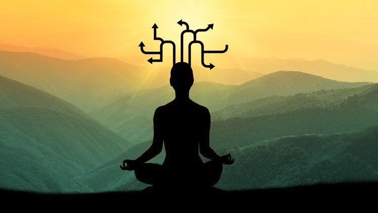 Silhouette of a person meditating in front of misty green mountains at sunrise, with arrows branching out from their head